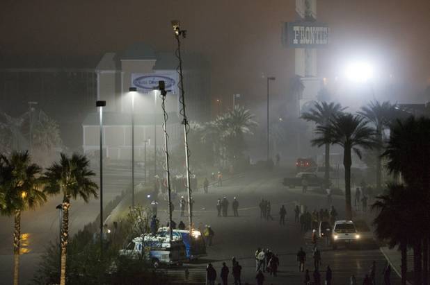 Dust from the implosion of the New Frontier hotel tower drifts over spectators and television crews in Las Vegas, Nevada November 13, 2007. The casino on The Las Vegas Strip was purchased by Elad properties, an Israeli-owned real estate investment group, for more than U.S. $1.2 billion in May 2007. Elad Group, which also owns the Plaza hotel in New York, and the IDB Group are expected to build a Plaza-themed, multi-billion dollar megaresort on the site. 